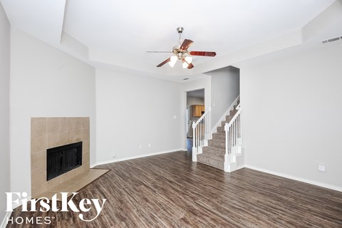 a living room with a fireplace and a ceiling fan