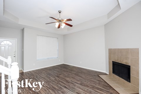 a living room with a fireplace and a ceiling fan