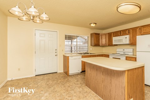 A kitchen with wooden cabinets and a white fridge.