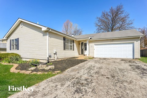 a home with a gravel driveway and a white garage door