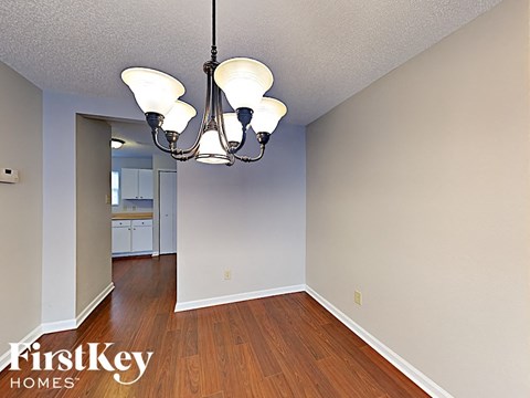 the living room and dining room with a chandelier and hardwood floor