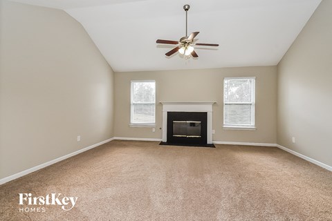 a living room with a fireplace and a ceiling fan