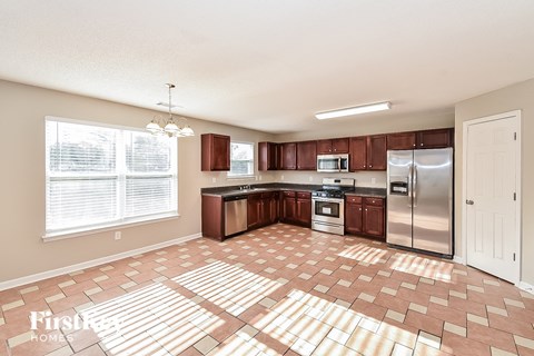 a kitchen with wooden cabinets and a stainless steel refrigerator