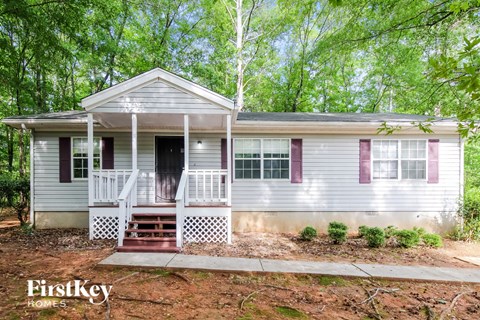 a white house with purple shutters and a front porch