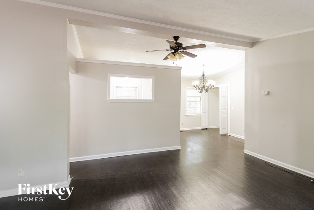 a living room with white walls and a ceiling fan