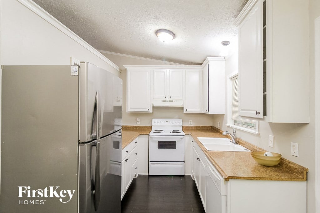 a white kitchen with white cabinets and stainless steel appliances