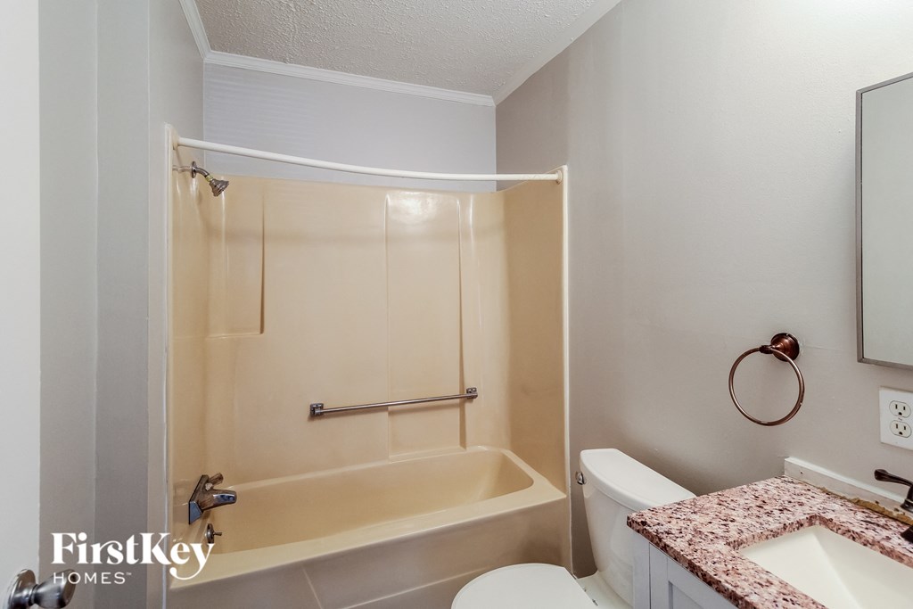 a bathroom with a shower and a toilet and a sink