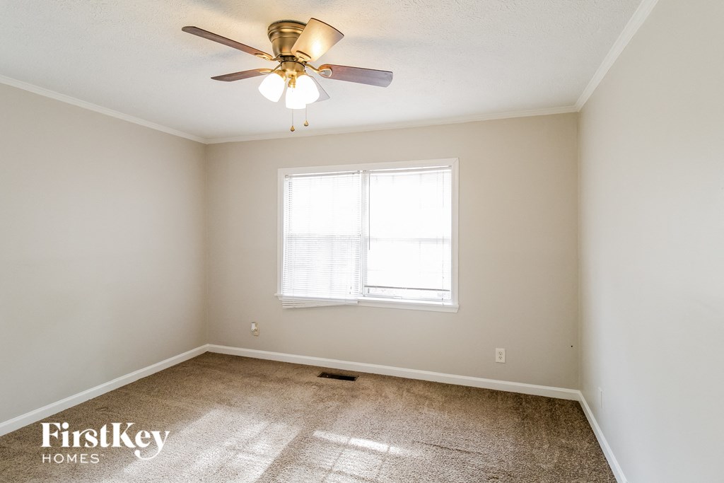 a bedroom with a ceiling fan and a window