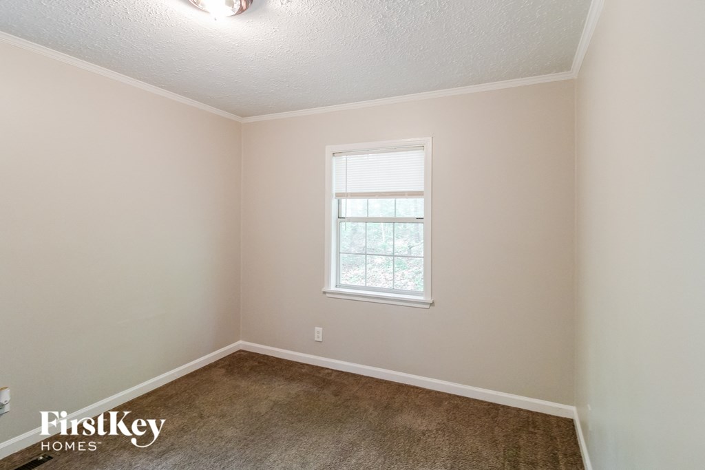a empty room with carpet and a window