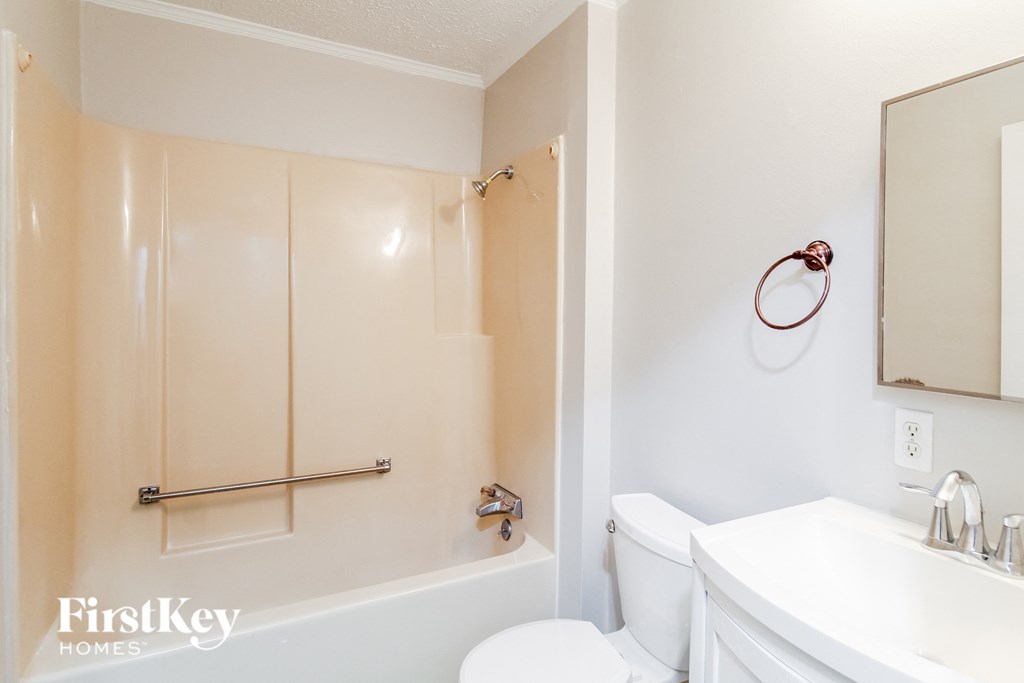 a bathroom with a white toilet and a tub and a sink
