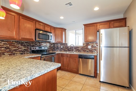 an updated kitchen with stainless steel appliances and granite counter tops