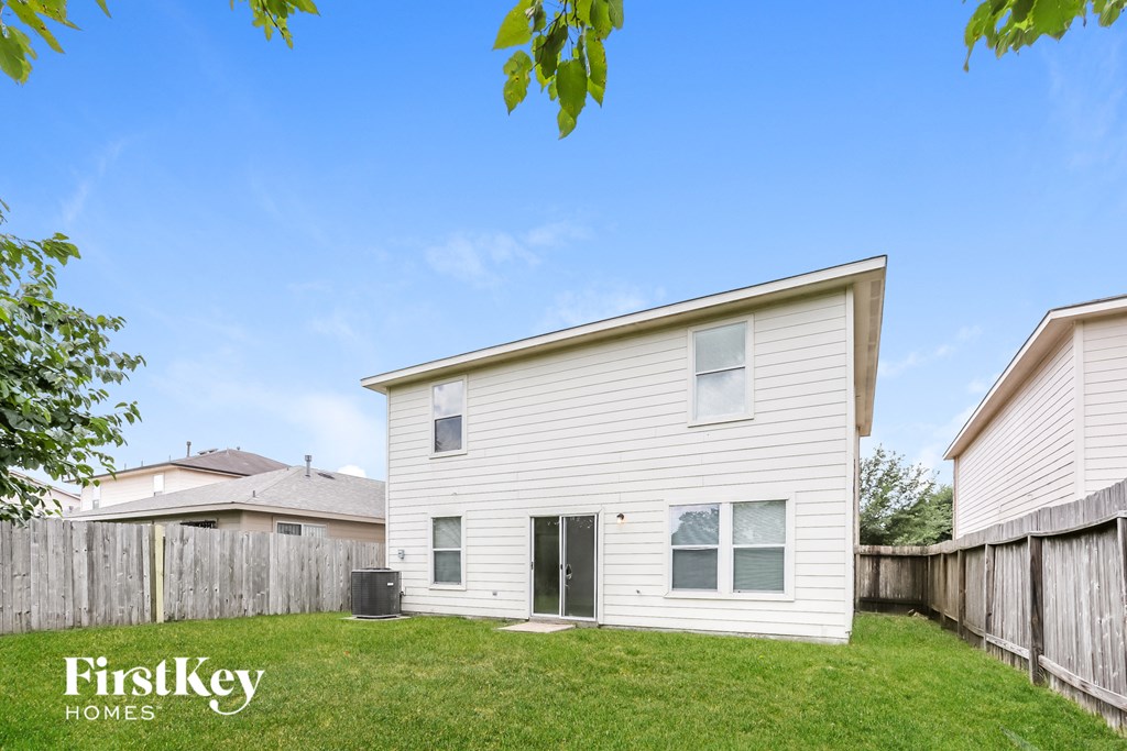 a white house with a yard and a wooden fence
