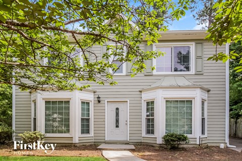 the exterior of a house with white siding and white windows