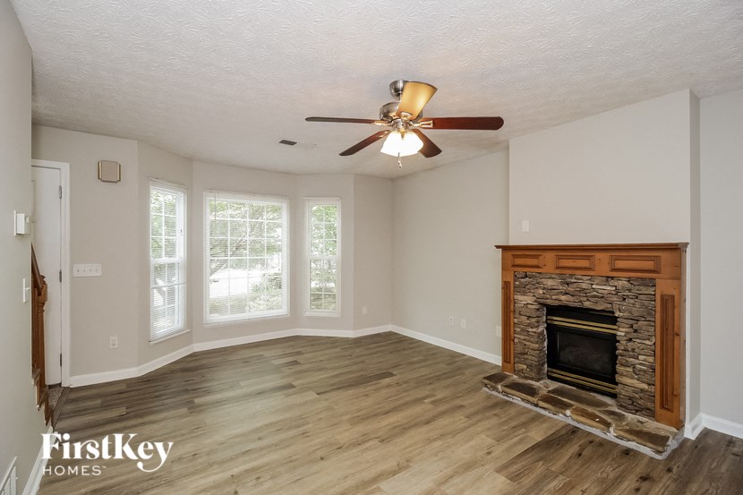 a living room with a fireplace and a ceiling fan