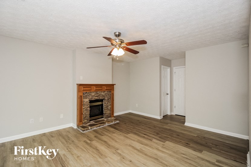 a living room with a fireplace and a ceiling fan