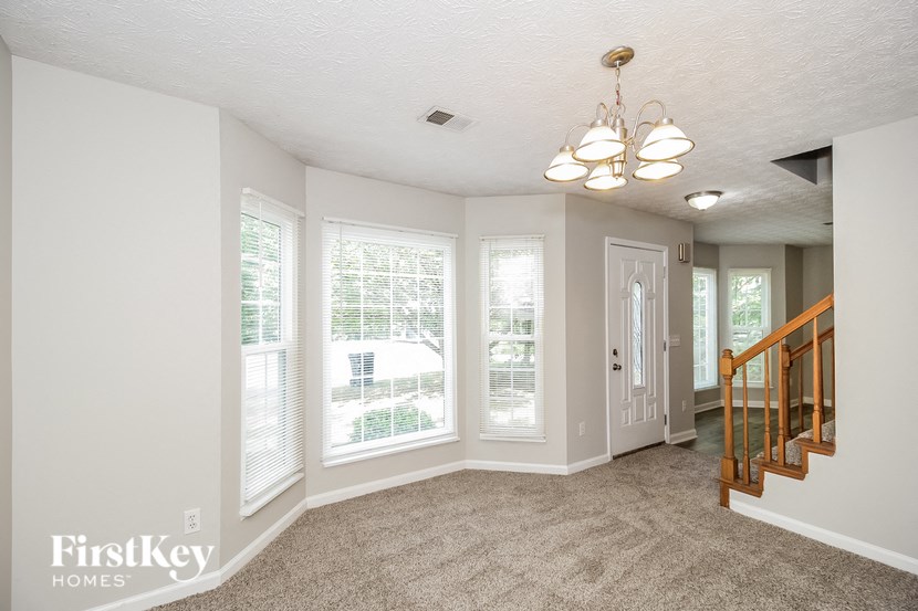 a living room with large windows and a staircase