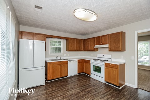 a kitchen with white appliances and wooden cabinets