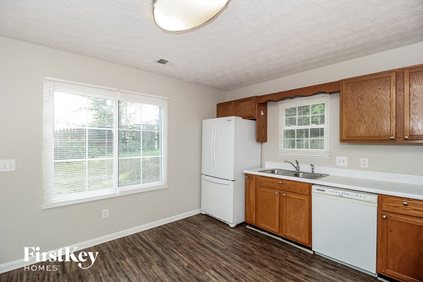 a kitchen with white appliances and wooden cabinets and a white refrigerator