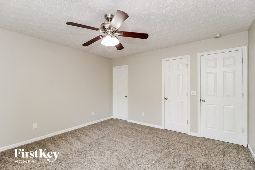 a bedroom with a ceiling fan and two doors