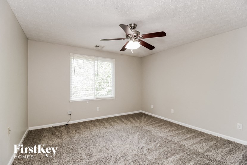 a bedroom with carpet and a ceiling fan