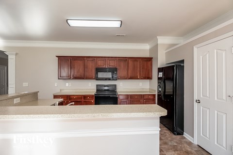 A kitchen with brown cabinets and a white counter.