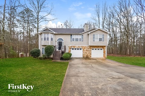 a white house with a driveway and a white garage door