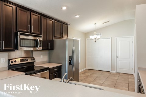 A kitchen with dark brown cabinets and stainless steel appliances.