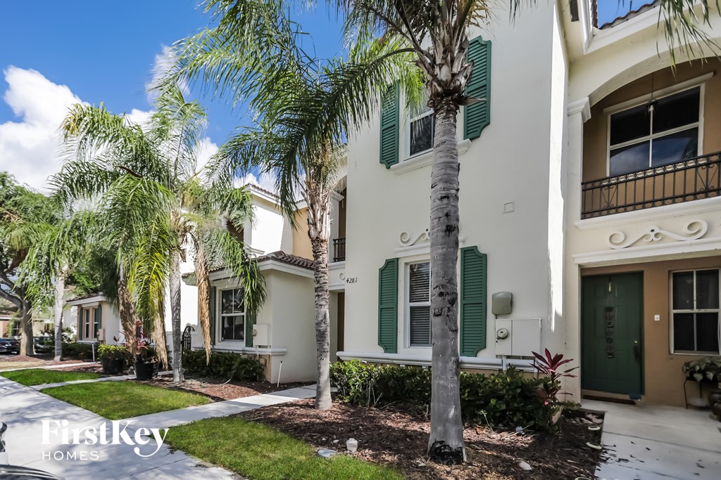 an apartment building with palm trees in front of it