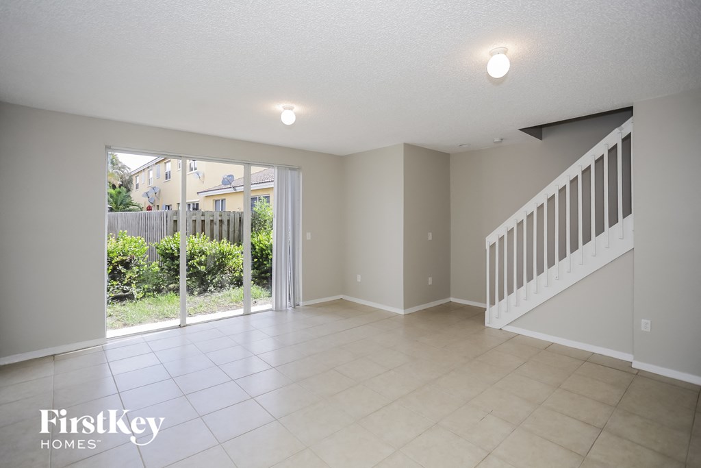 a spacious living room with a sliding glass door to the patio