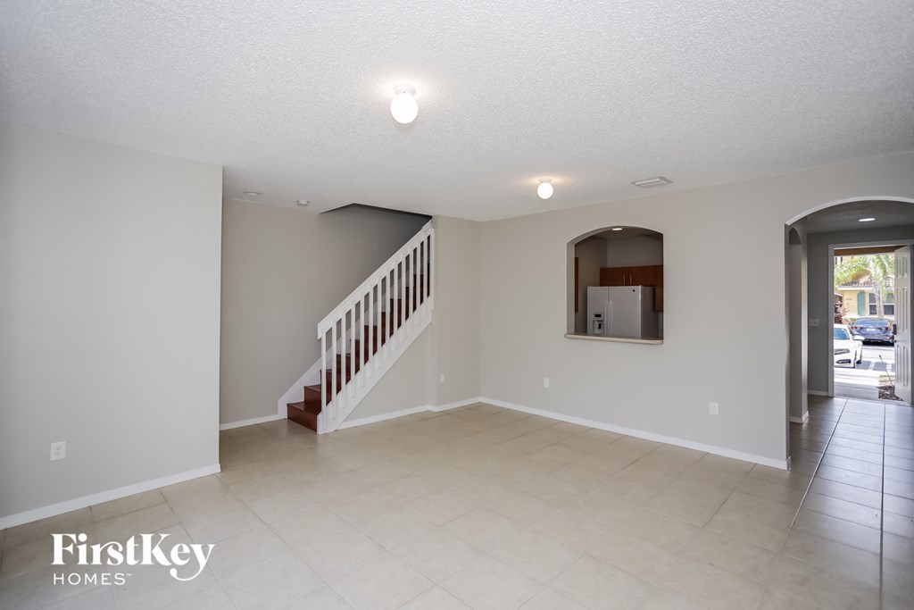 the living room and entryway with the staircase to the second floor