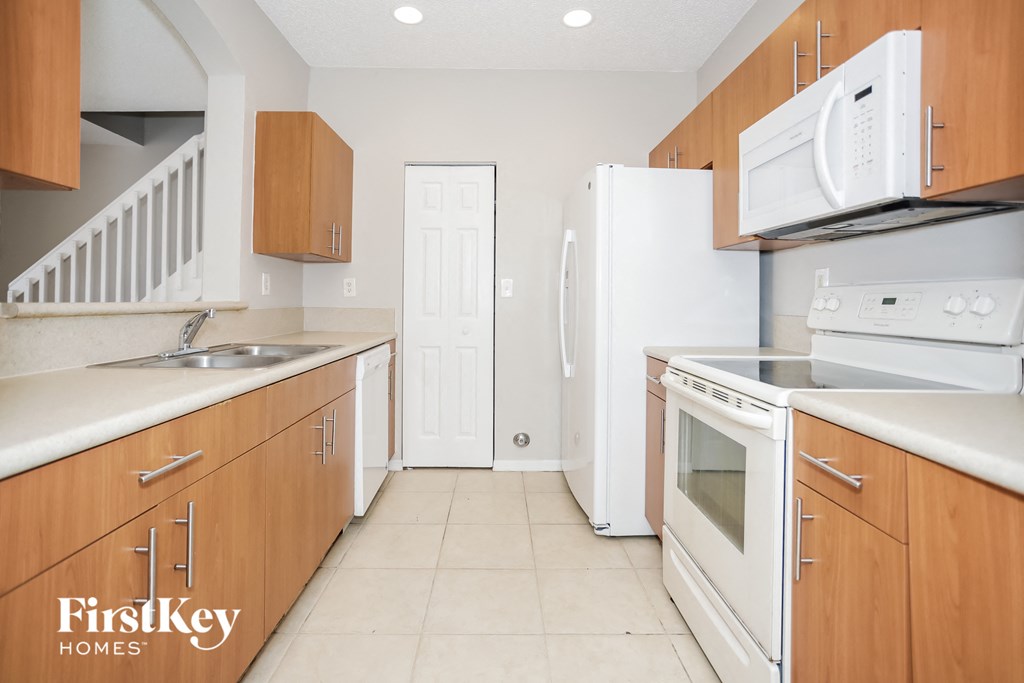 a kitchen with white appliances and wooden cabinets