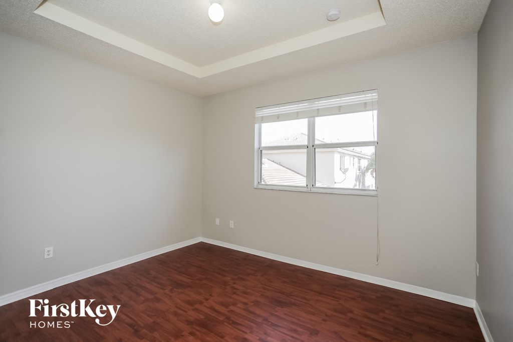 a bedroom with wood flooring and a window