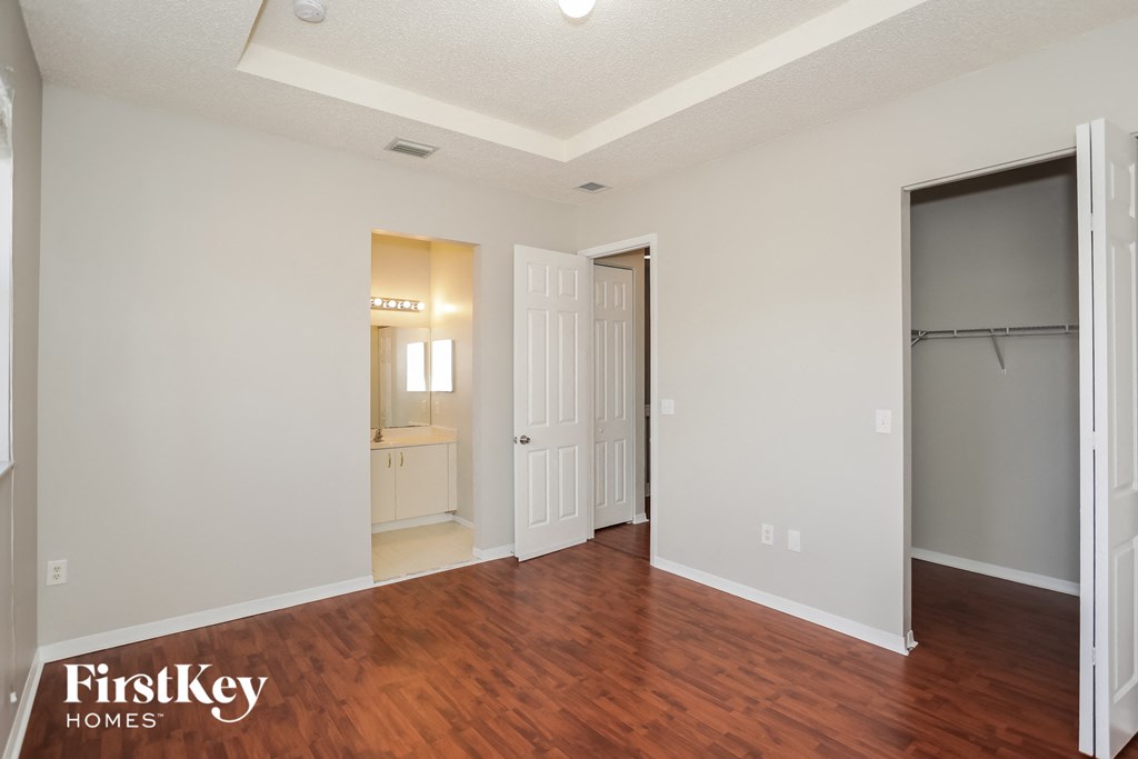 a living room with a hard wood floor and a door to a bathroom