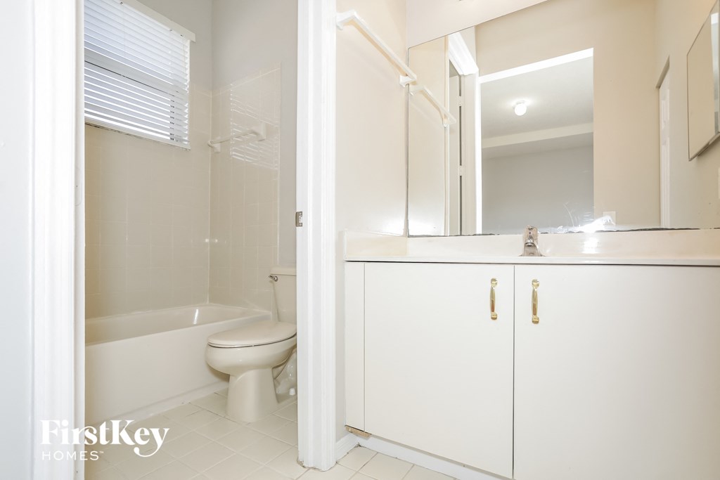 a bathroom with a toilet and a sink and a bath tub