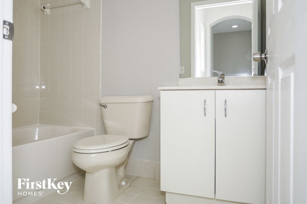 a bathroom with a toilet and a sink and a bath tub