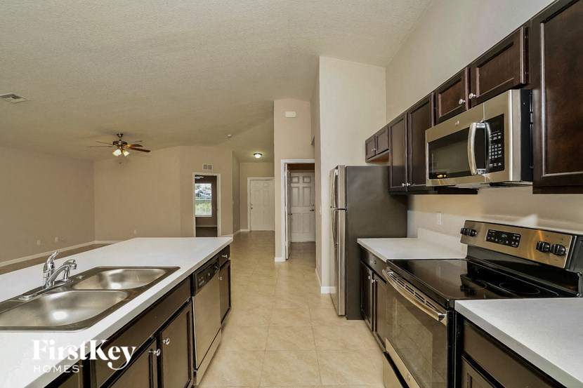 A kitchen with a sink, stove, and refrigerator.