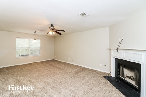 a living room with a fireplace and a ceiling fan