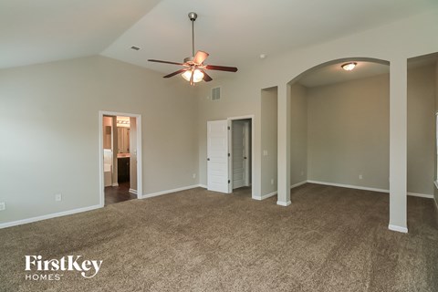 a living room with carpet and a ceiling fan