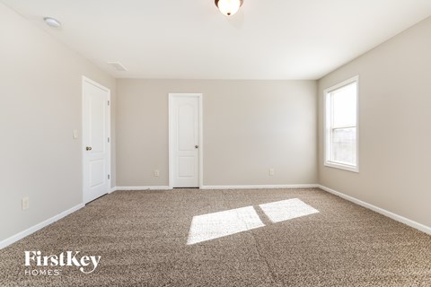 a spacious living room with carpet and a window
