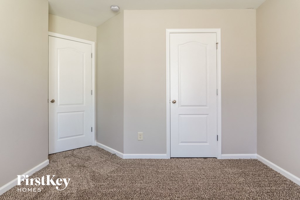 a bedroom with two white doors and a carpeted floor