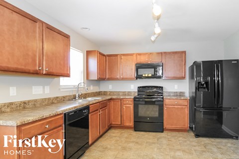 a kitchen with black appliances and wooden cabinets and a counter top