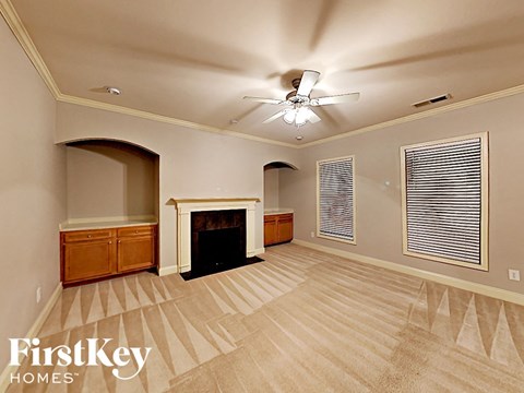 A living room with a fireplace and a carpet with a pattern.