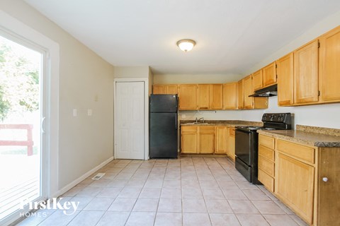 A kitchen with wooden cabinets and black appliances.