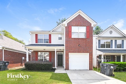 a brick house with a white garage door and a driveway