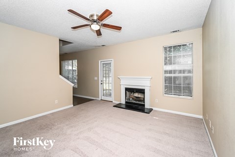 a living room with a fireplace and a ceiling fan