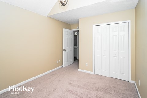 a bedroom with two closets and a carpeted floor