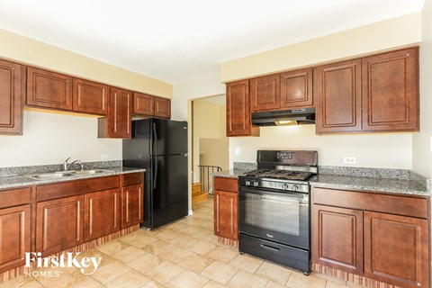 A kitchen with wooden cabinets and black appliances.