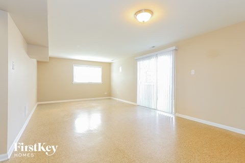 A spacious room with a window and a sliding door.