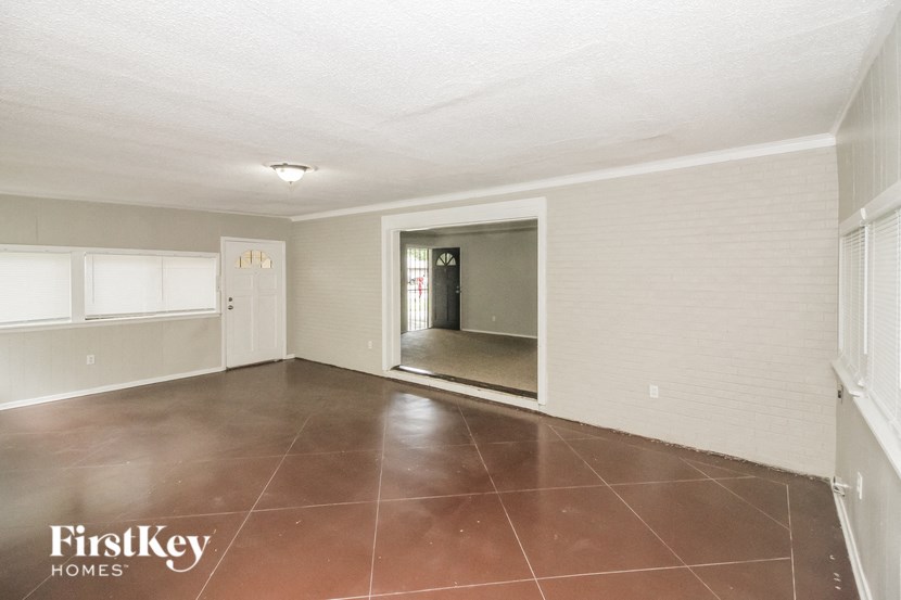 an empty living room with a door to a hallway
