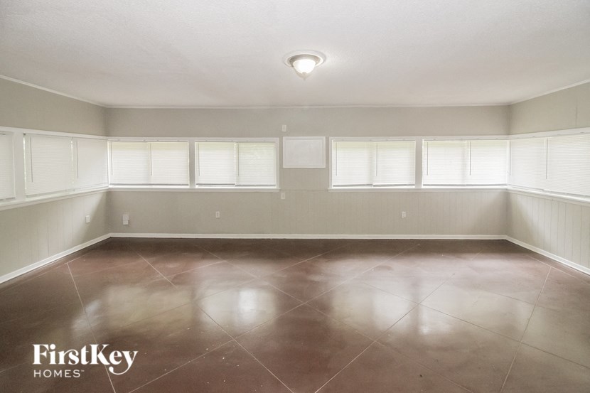 a empty room with a shiny floor and white windows